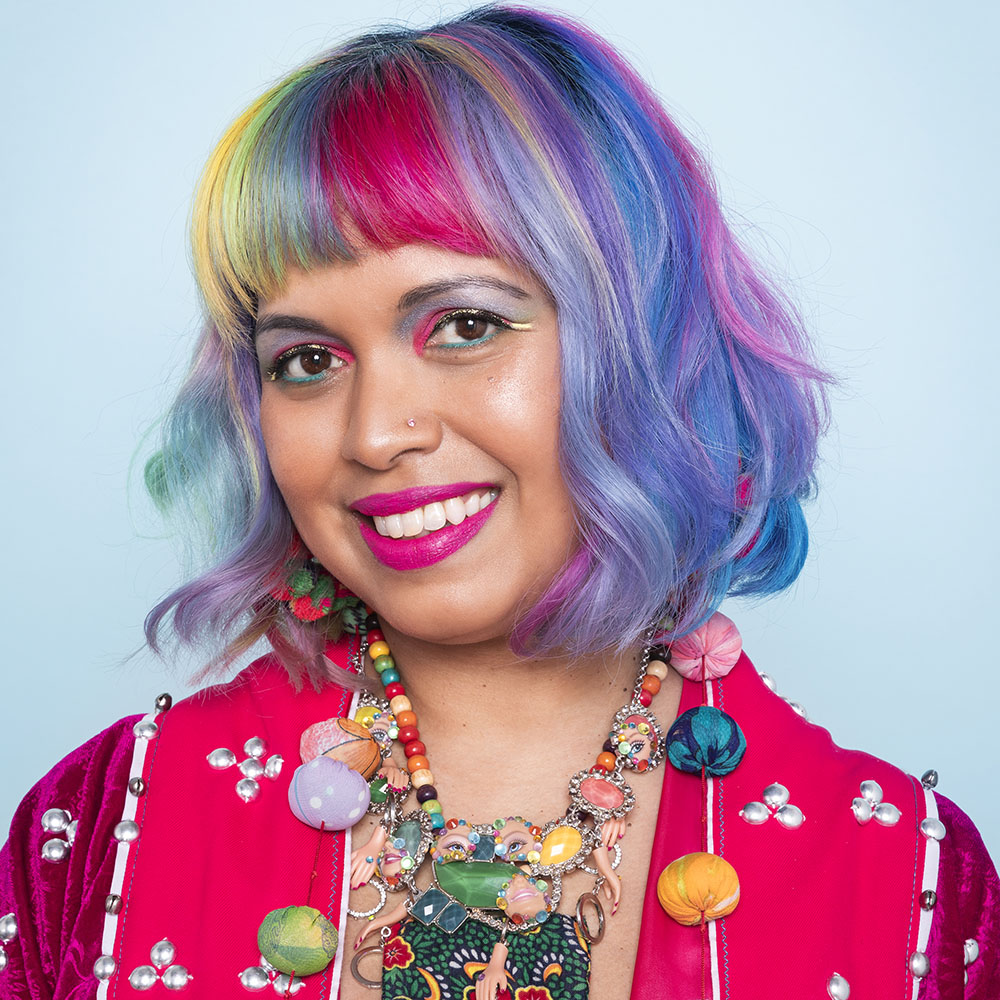 Momtaz is the author of the blog, she has rainbow hair and is wearing pompoms and a pink jacket