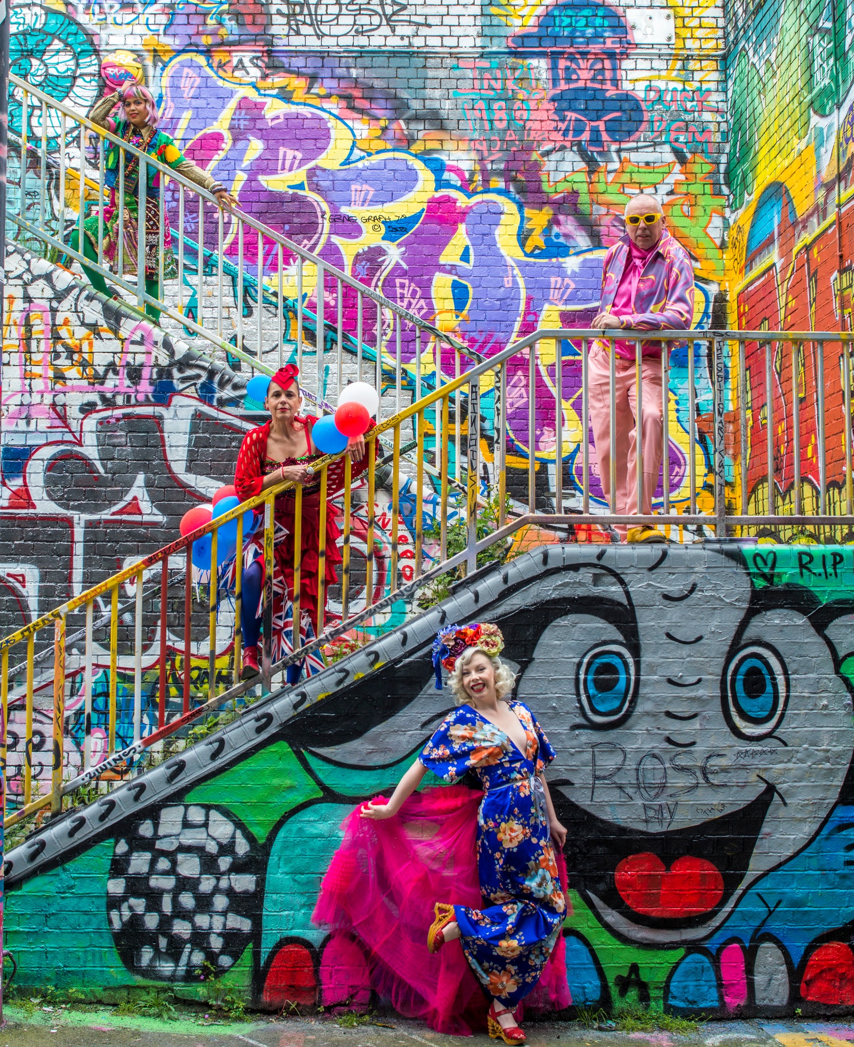 street art staircase with 4 colourfully dressed people standing on different levels