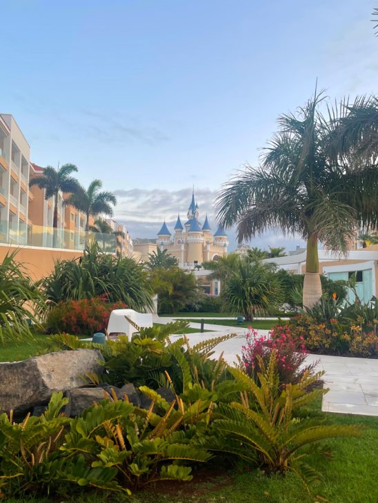 View of Bahia Principe Fantasia Tenerife hotel with trees and plants in foreground