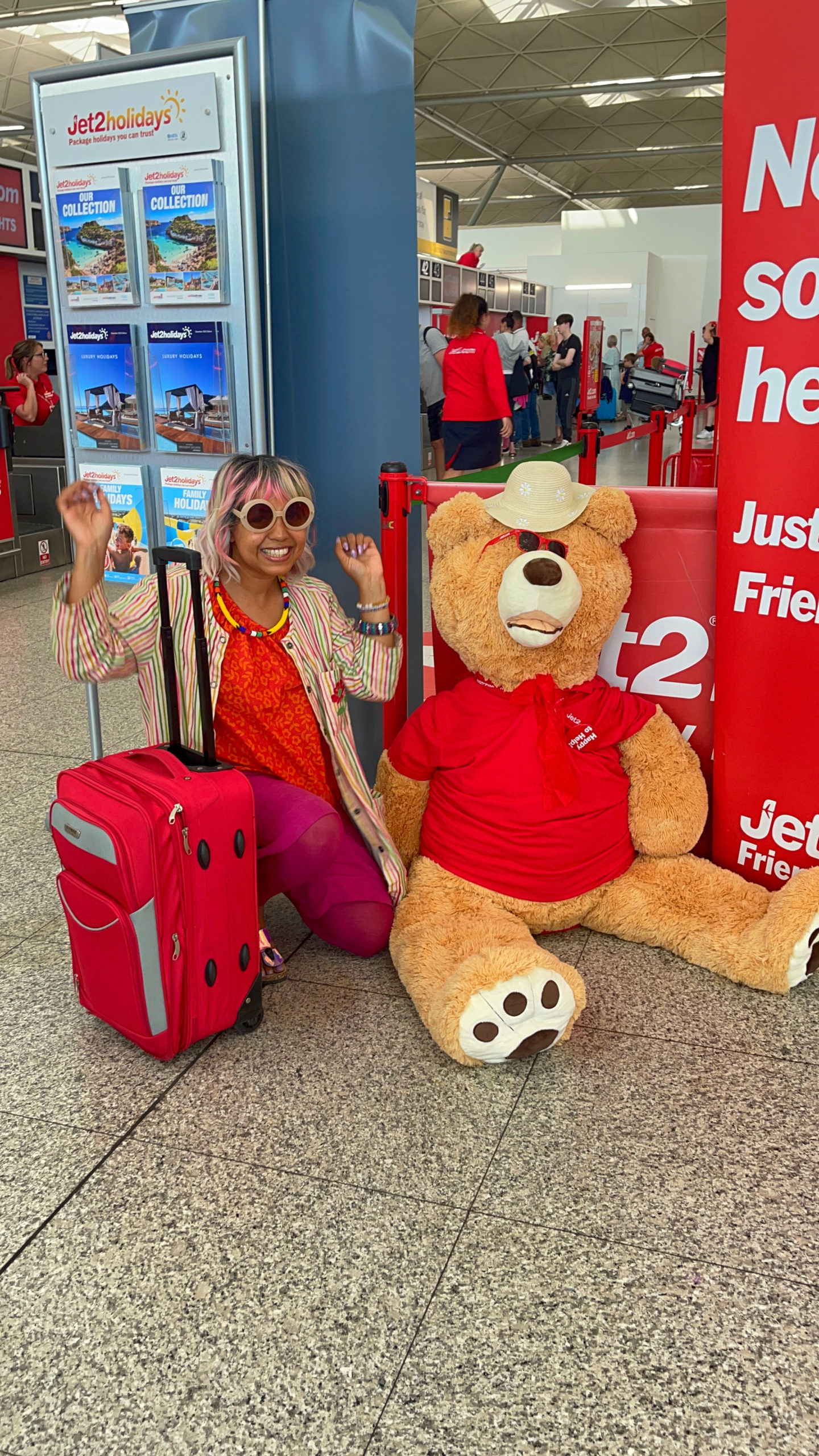 Jet 2 mascot bear sat on the floor with happy passenger 
