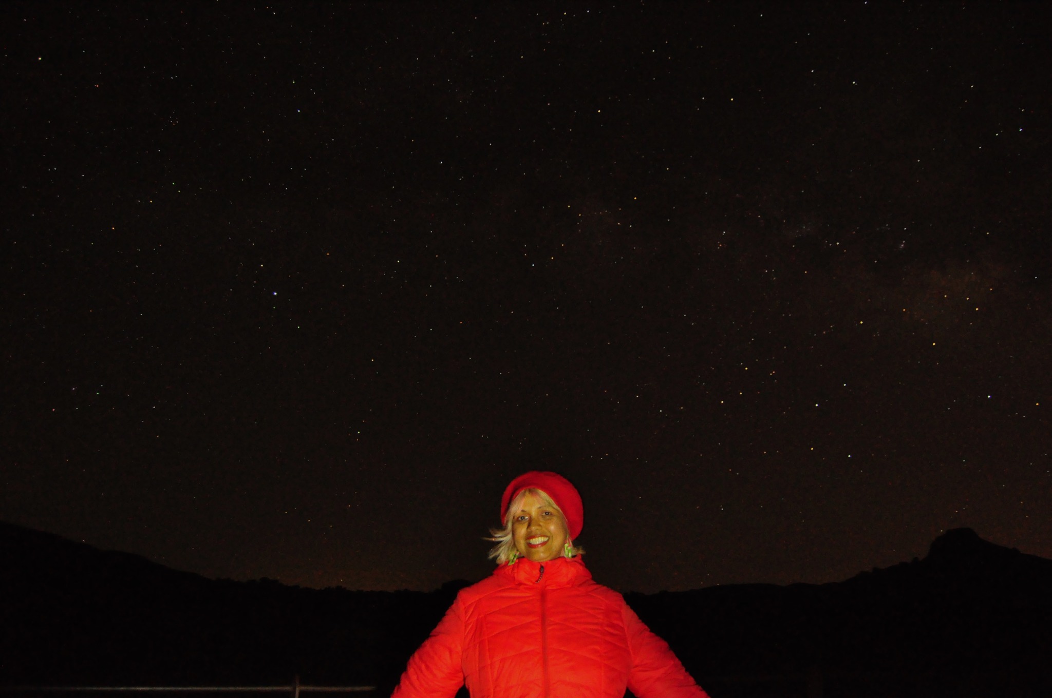 girl in red jacket smiling under the stars