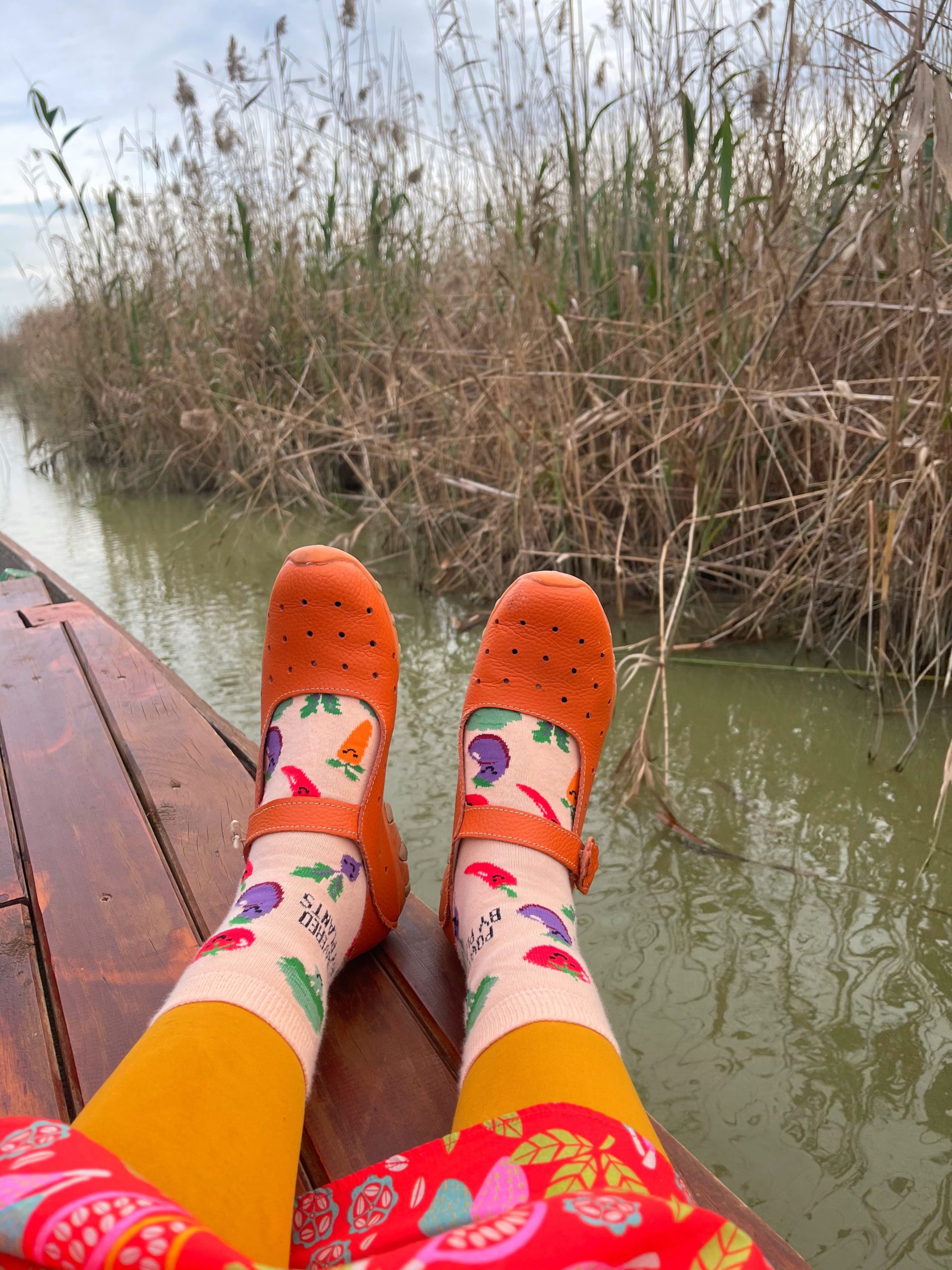 legs on a boat on a lake passing through by river plants