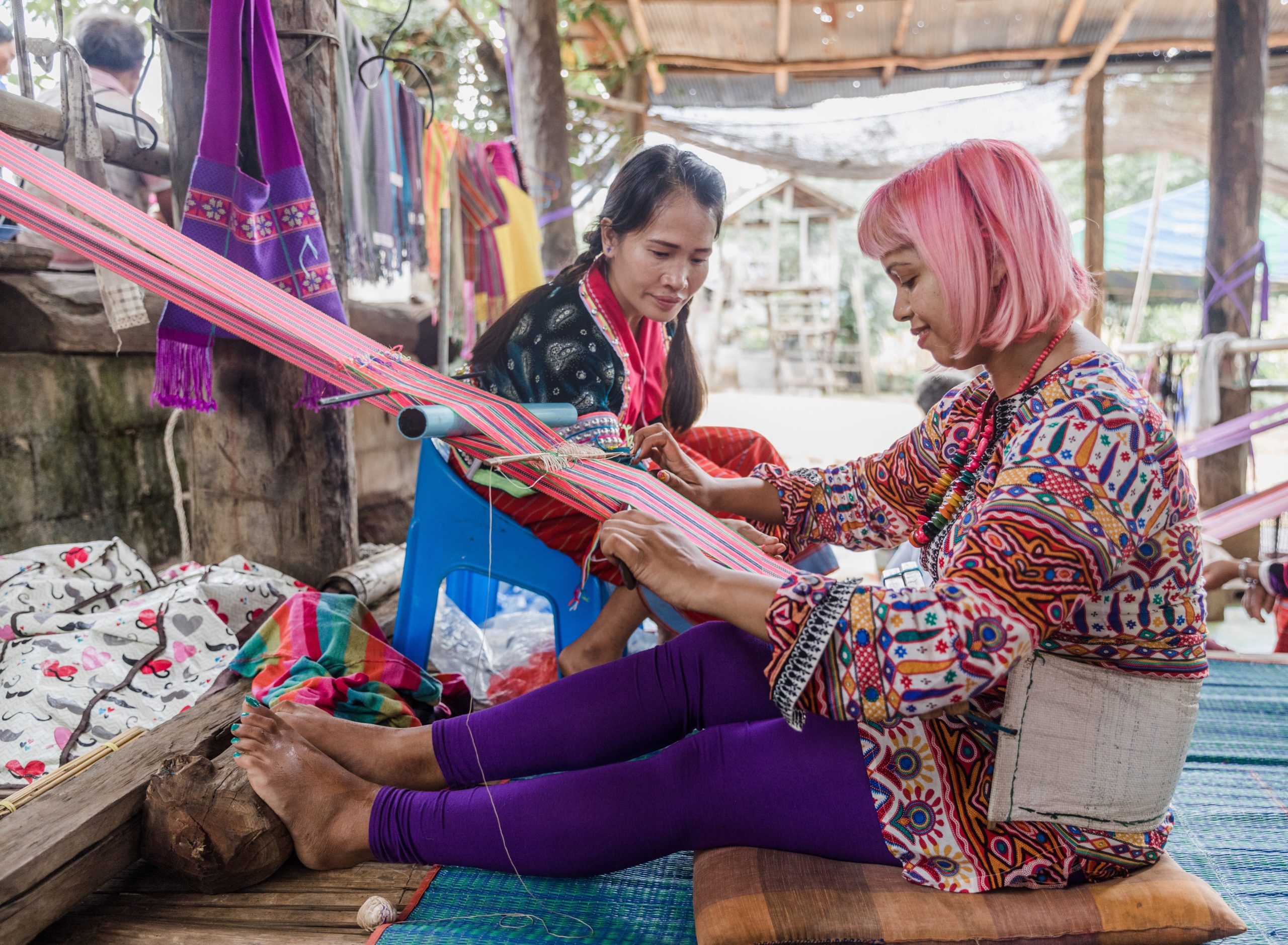 momtaz sat on floor working a backstap loom weaving a bag