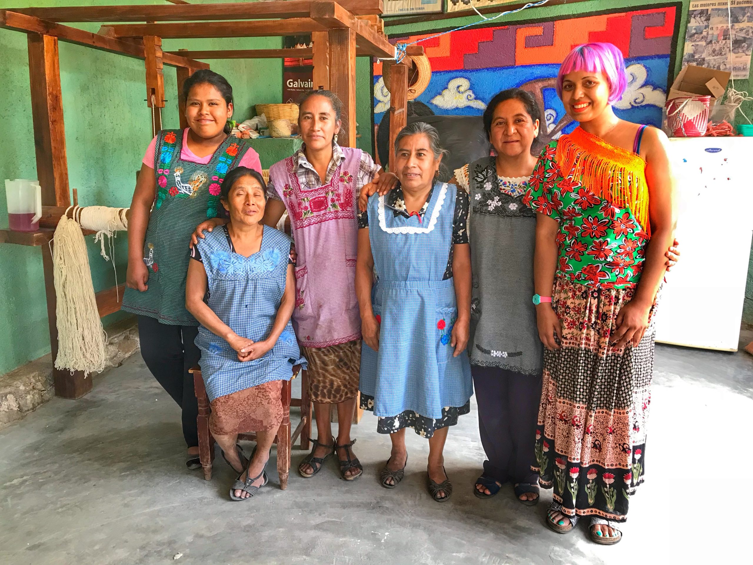 four of the women from via nueva coop standing in their weaving studio with momtaz