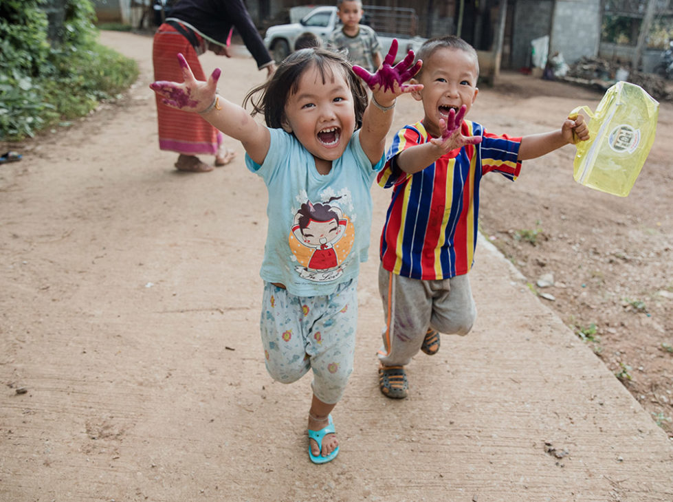 two laughing children running into the camera lens