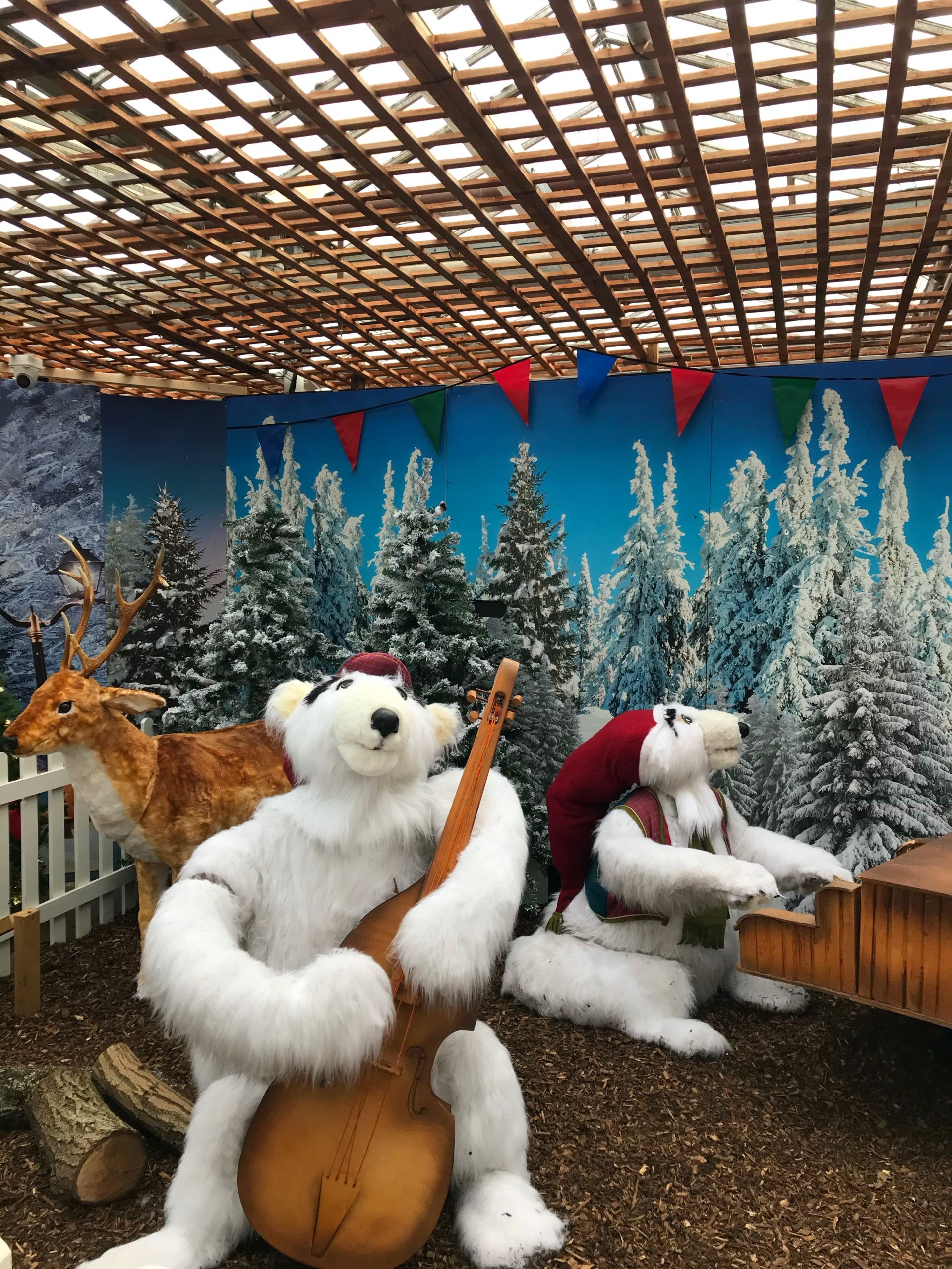 giant furry bears in a christmas scene  playing instruments in a garden centre