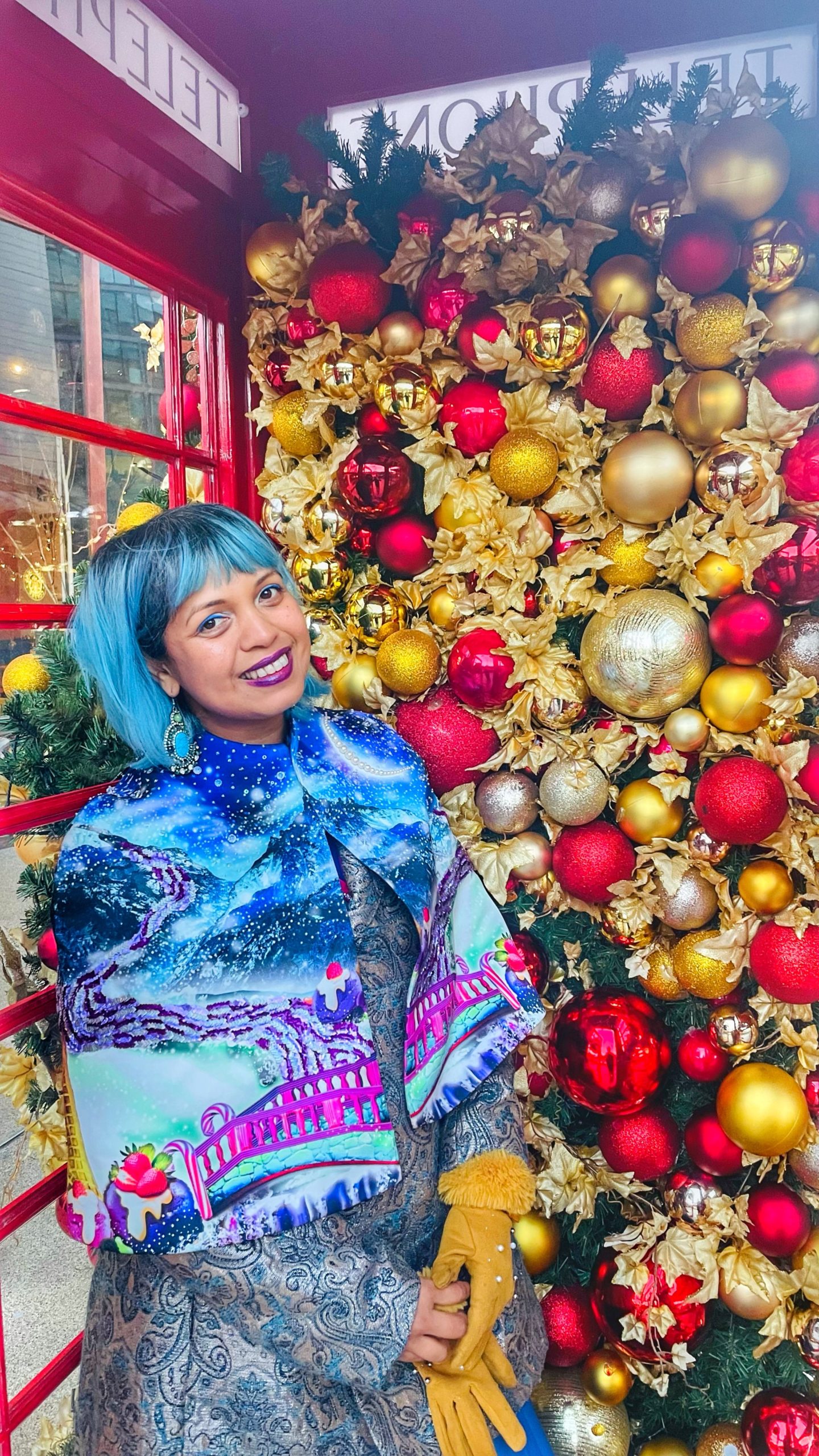 momtaz standing in a phone box filled with baubles