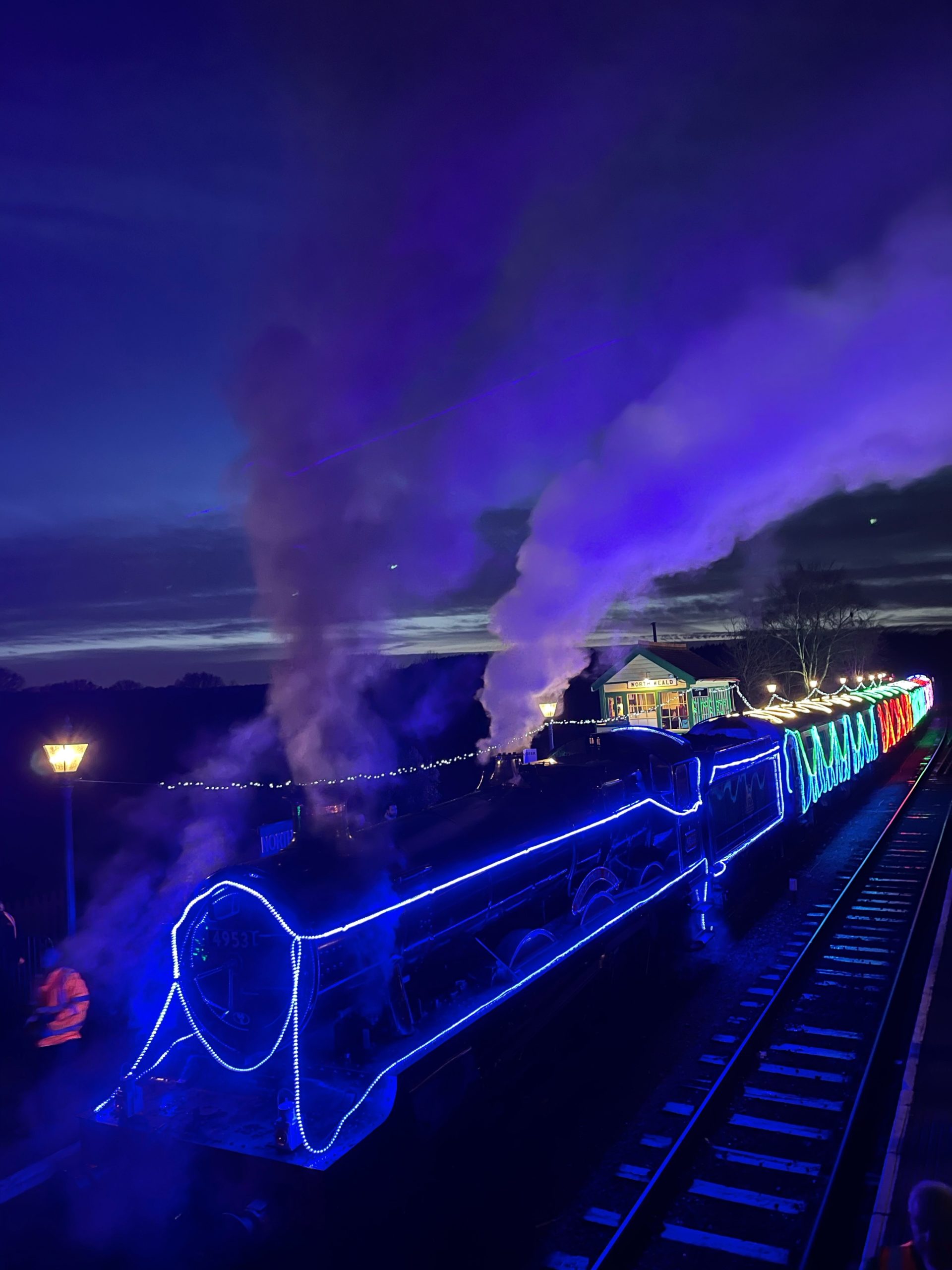 steam train at night lit up with christmas lighs