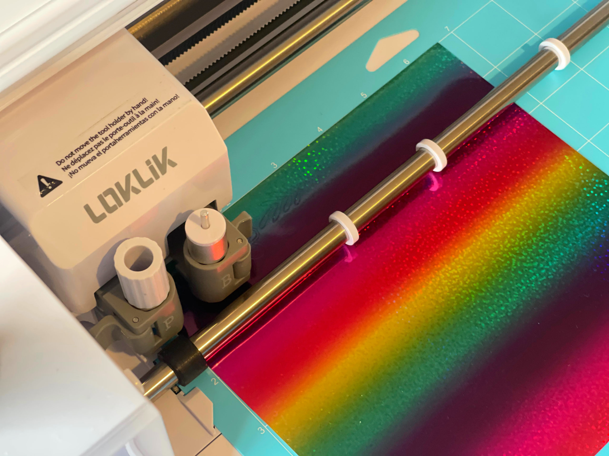 close up of loklik crafter cutting machine cutting rainbow vinyl