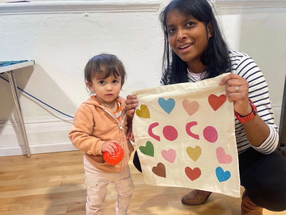 lady and daughter holding up a customised tote bag covered in hearts that says coco