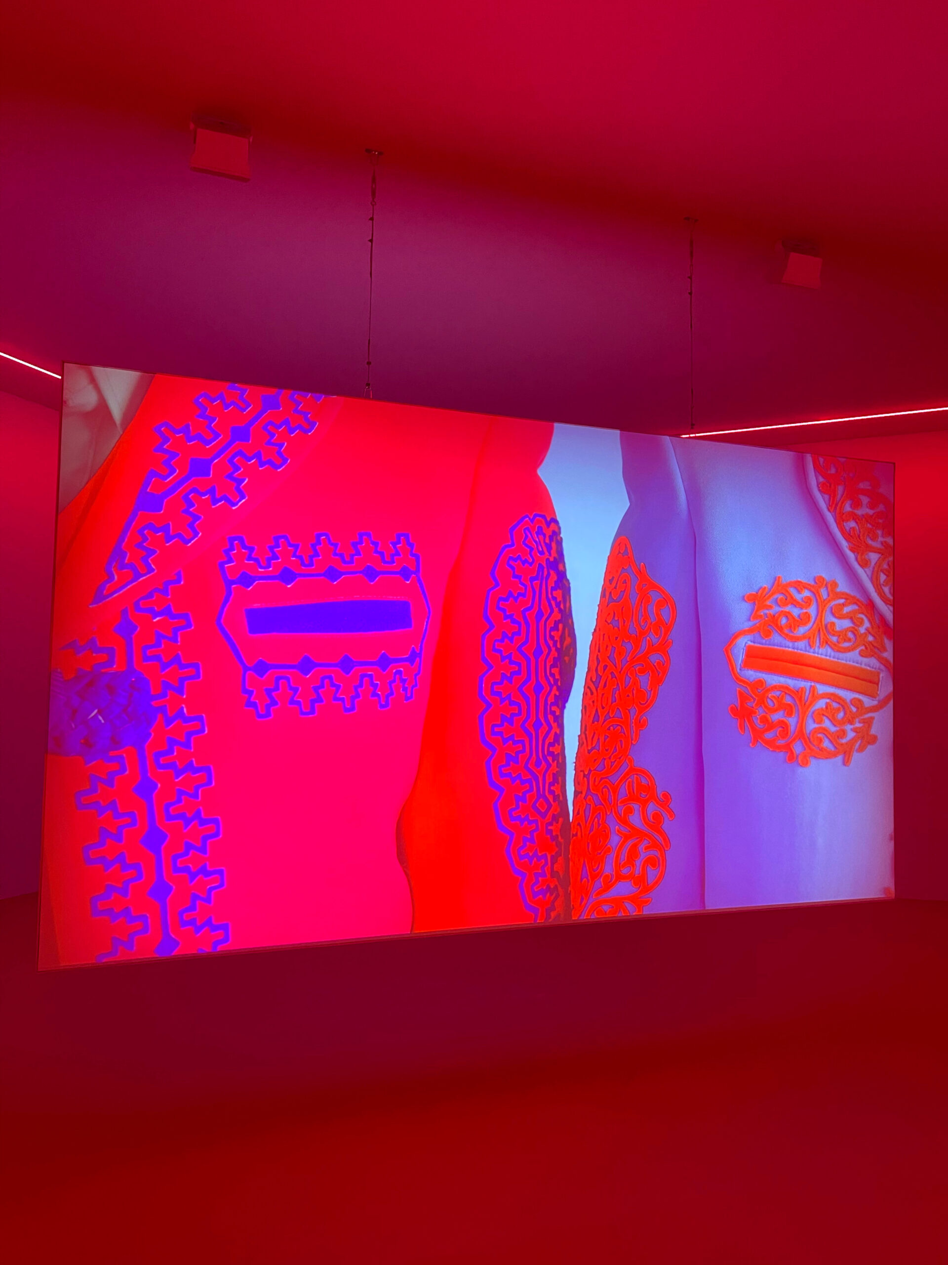 a red room with a digital screen that has motif on it and red and purple