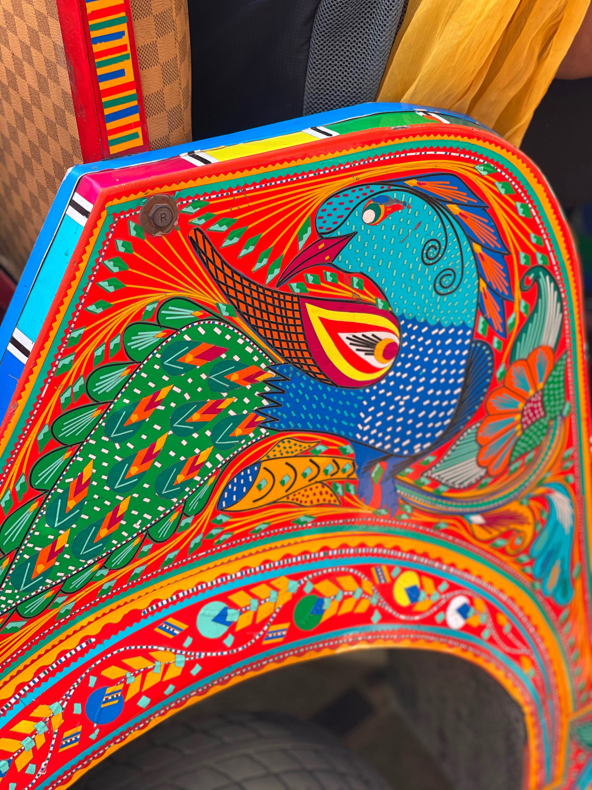 close up of  a peacock using the chamak patti stickering technique, pakistani truck art
