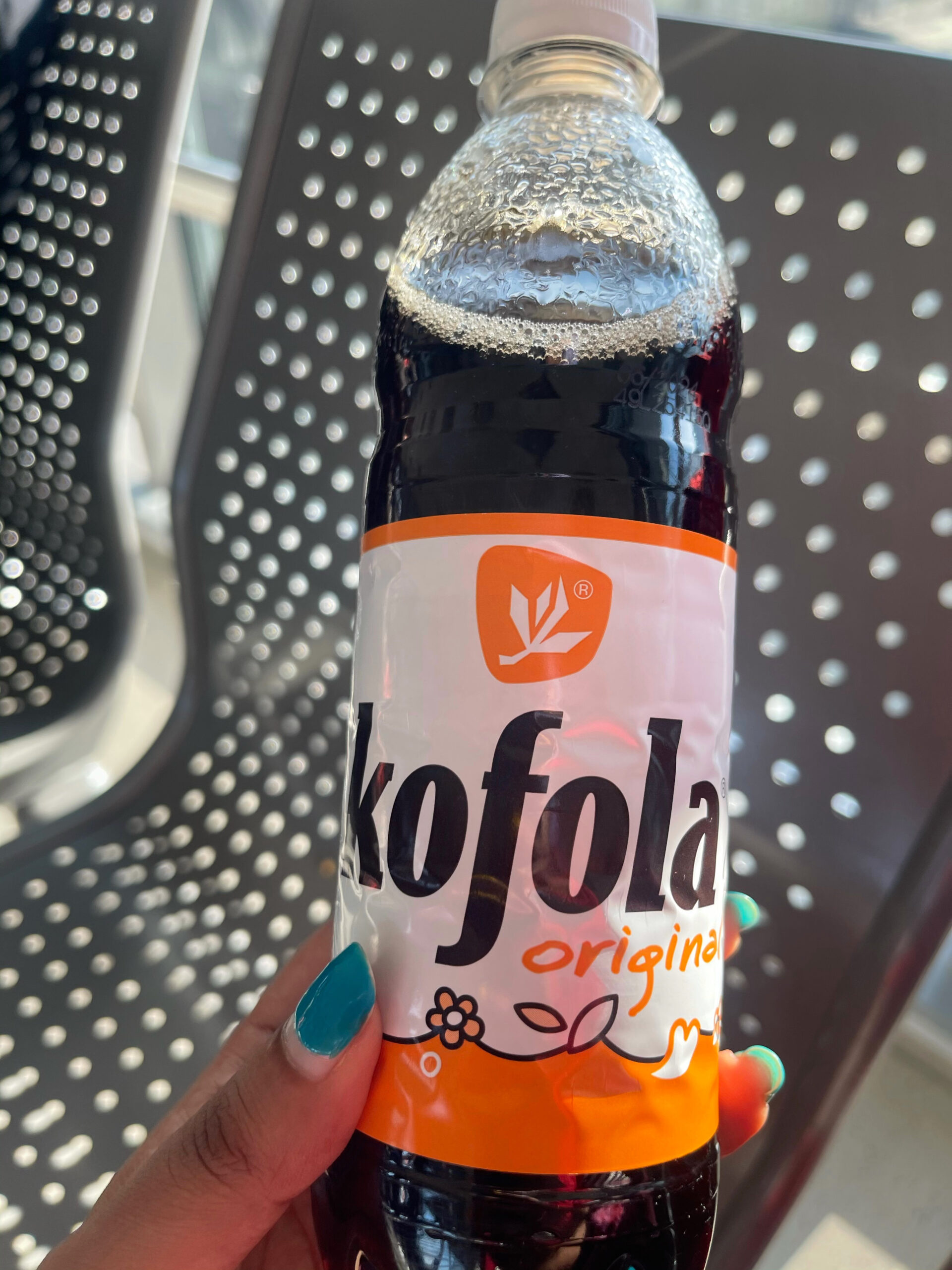 a bottle of kofola it looks like a dark drink the wrapper is white and orange