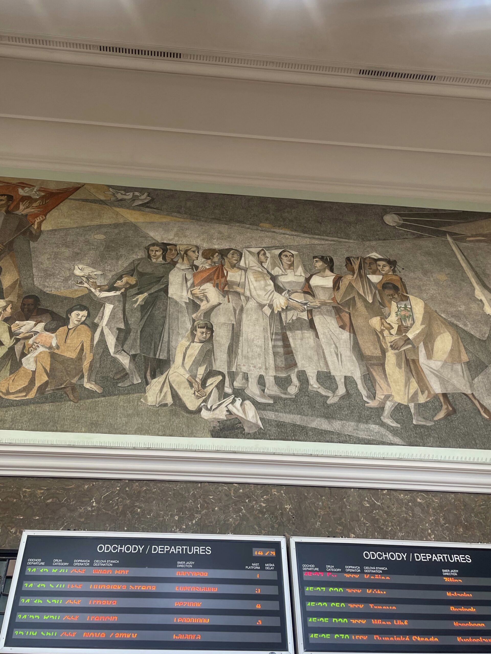 photo pf a mosaic above the departure boards. It has historically dressed people on it