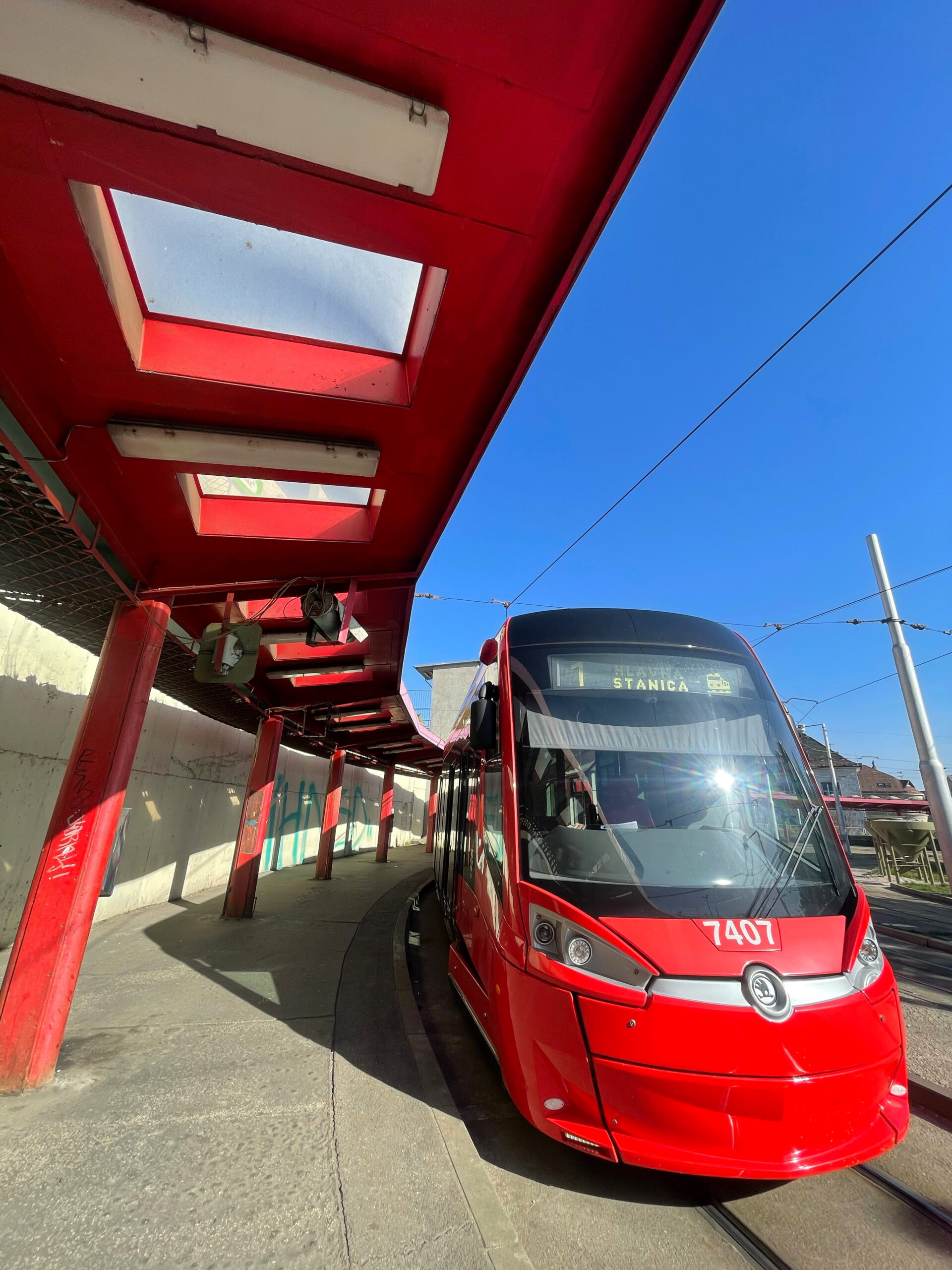 photo of a red tram at a tram station
