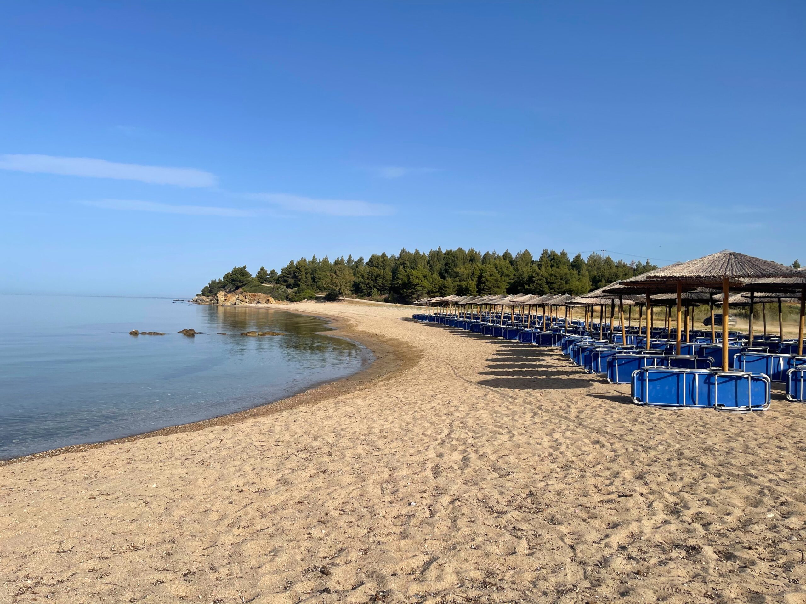 sandy beach with sunloungers in greece