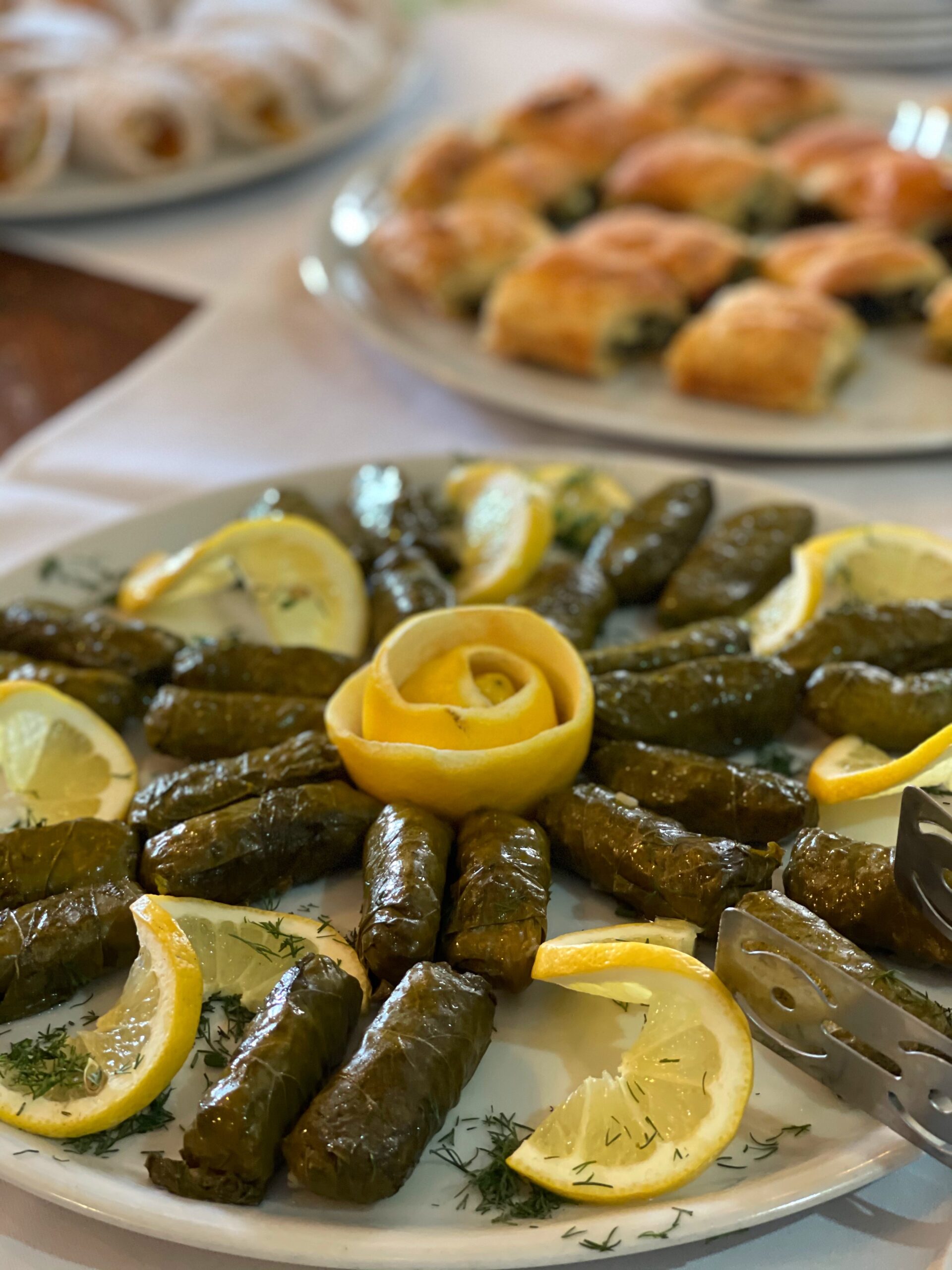 huge plate of dolmadas presented with lemon slices