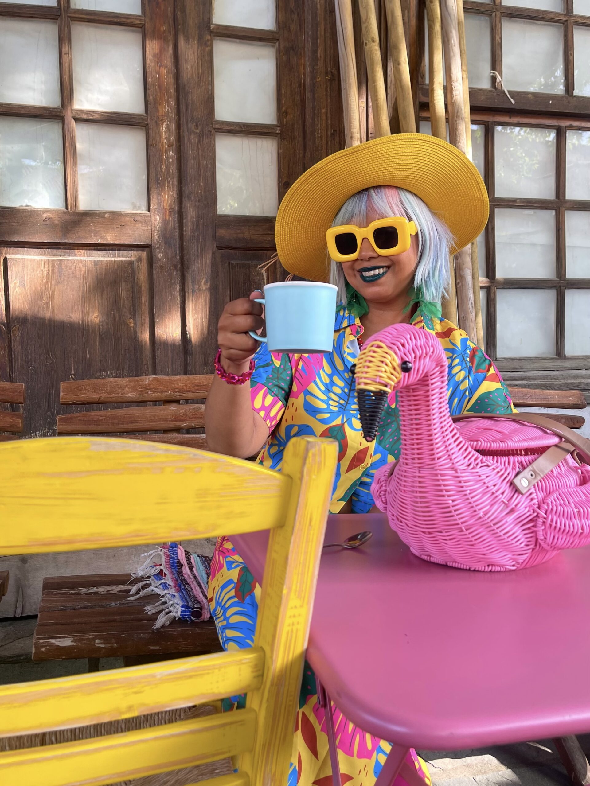 happy girl at pink and yellow cafe with pink flamingo basket bag